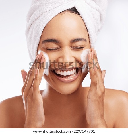 Glowing skin is something you have to maintain. Studio shot of a beautiful young woman washing her face against a white background.