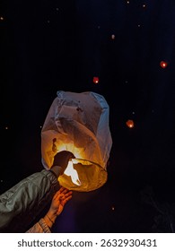 A glowing sky lantern released into the night sky—capturing a magical moment of hope, wishes, and celebration. Perfect for festival, night photography, or cultural tradition content.