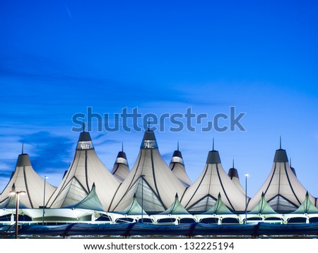 Glowing tents of DIA at sunrise. Denver International Airport well known for peaked roof. Design of roof is reflecting snow-capped mountains.