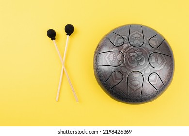 glucophone instrument and sticks for playing music. The inscription in Sanskrit OM