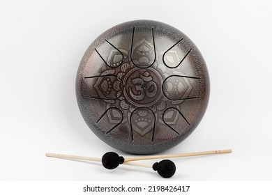 glucophone instrument and sticks for playing music. The inscription in Sanskrit OM