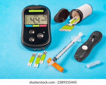 Glucose meter, syringe and test strips on blue background - Powered by Shutterstock