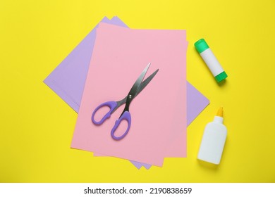 Glue, Colorful Paper And Scissors On Yellow Background, Flat Lay