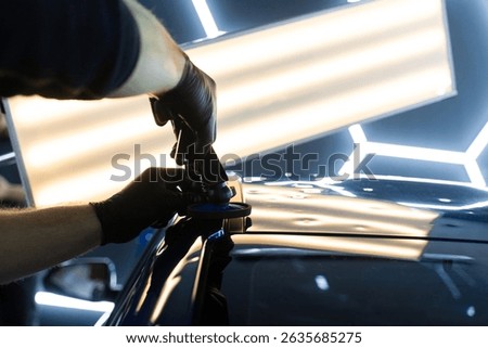 The glue pulling method repairs a curved rear panel, preserving OEM paint. Glue dent puller in action fixes rear fender dent, preserving the paintwork. Precision glue tabs lift car body dent smoothly