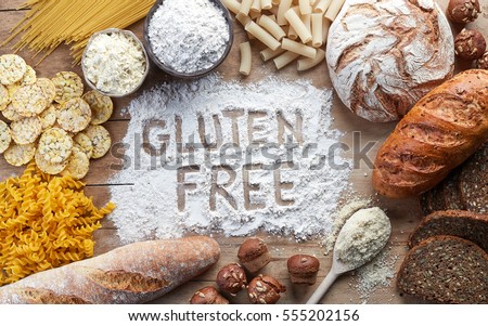 Gluten free food. Various pasta, bread, snacks and flour on wooden background from top view