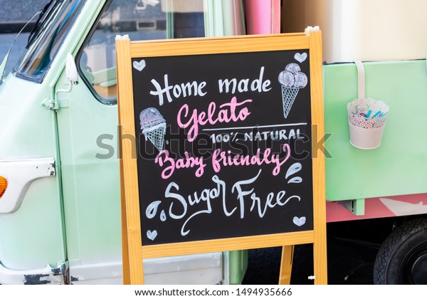 Gluten free, lactose free, gluten free ice cream\
sign. Advertisement on chalk board during food festival. Vintage\
retro italian car behind the sign. intolerance free dessert shop\
directional ad text