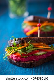gluten free vegan sandwiches with beet hummus, raw vegetables and sprouts