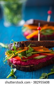 gluten free vegan sandwiches with beet hummus, raw vegetables and sprouts