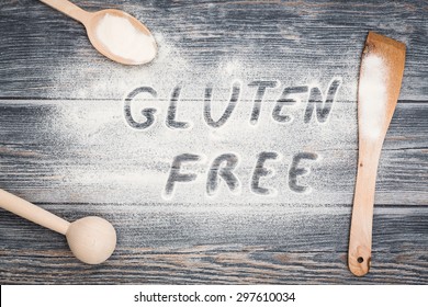 Gluten Free Word Written On Flour. Table Wooden Background.