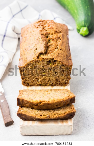 Gluten free zucchini bread slices on\
concrete background. Selective focus, space for\
text.