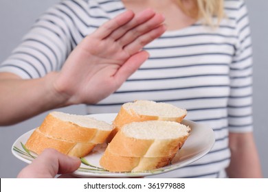 Gluten Intolerance And Diet Concept. Woman Refuses To Eat White Bread. Selective Focus On Bread