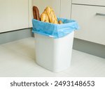 gluten intolerance, overconsumption, organic  food waste, zero-waste sustainable concept. copy space. stale spoiled bread  in the  garbage bin in the kitchen