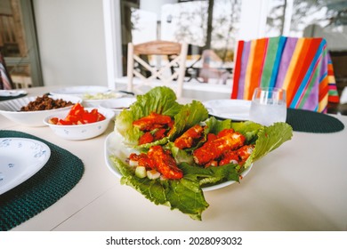 Gluten-free Buffalo Tofu And Tempeh Lettuce Sandwich Wraps With Toppings Set On Dinner Table