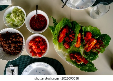 Gluten-free Buffalo Tofu And Tempeh Lettuce Sandwich Wraps With Toppings Set On Dinner Table