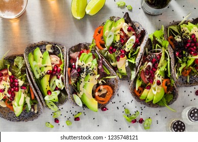 Gluten-free vegan tacos from black bean  with tomato and avocado salad  with tahini sauce and pomegranate seeds. healthy fast food for the whole family or party and beer - Powered by Shutterstock