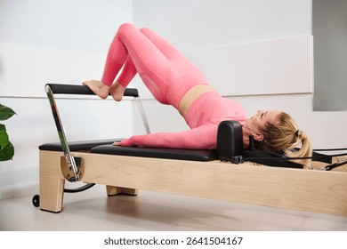 Glutes exercise on reformer machine. Mature woman during pilates workout