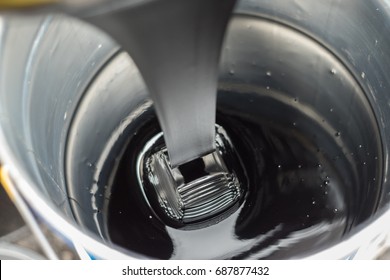 Glutinous Asphalt Bitumen slowly drop into a metal bucket