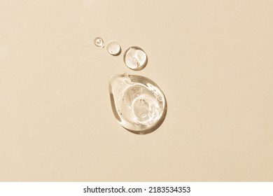 Glycerin gel texture. Transparent serum drop on beige background. Liquid gel moisturizer with bubbles macro.