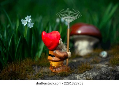 Gnome gardener with a rake.Mushroom meadow with bright flowers.Working gnomes in a fairy garden.Curious gnome in search of mushroom places.
				