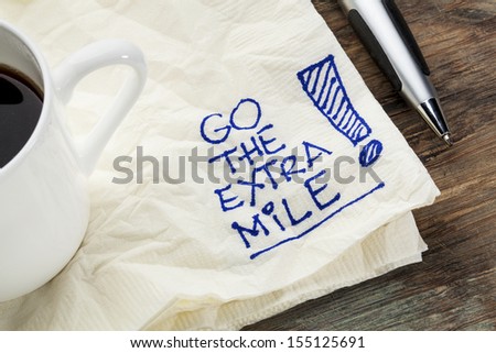 go the extra mile - motivational slogan on a napkin with a cup of coffee