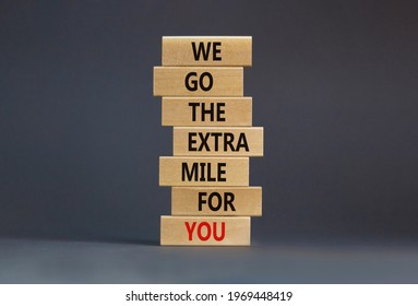 Go The Extra Mile Symbol. Wooden Blocks With Words 'We Go The Extra Mile For You'. Beautiful Grey Background. Business, Motivational And Go The Extra Mile Concept. Copy Space.