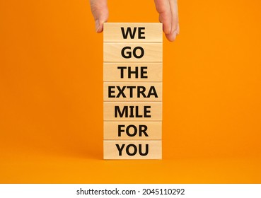 Go the extra mile symbol. Wooden blocks with words 'We go the extra mile for you'. Businessman hand. Beautiful orange background. Business and go the extra mile concept. Copy space. - Shutterstock ID 2045110292