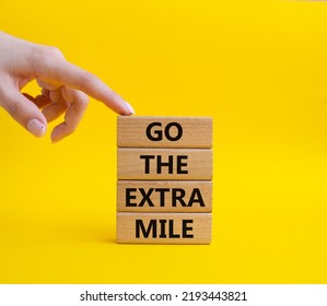 Go The Extra Mile Symbol. Wooden Blocks With Words Go The Extra Mile. Beautiful Yellow Background. Businessman Hand. Business And Go The Extra Mile Concept. Copy Space.