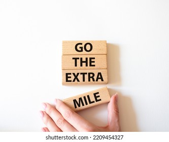 Go the extra mile symbol. Wooden blocks with words Go the extra mile. Beautiful white background. Businessman hand. Business and Go the extra mile concept. Copy space. - Shutterstock ID 2209454327