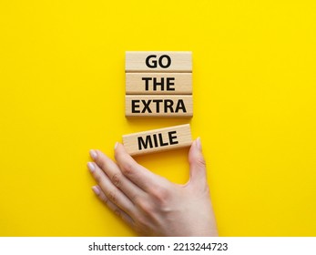 Go The Extra Mile Symbol. Wooden Blocks With Words Go The Extra Mile. Beautiful Yellow Background. Businessman Hand. Business And Go The Extra Mile Concept. Copy Space.