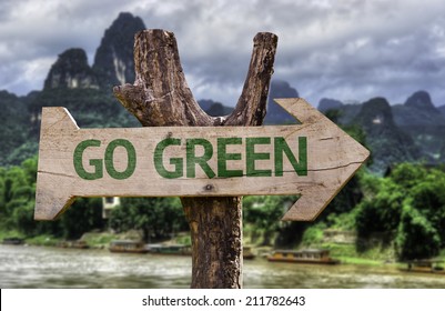 Go Green wooden sign with a forest background 