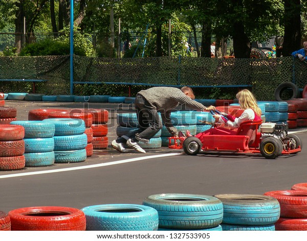 Go Kart Racer on the Track. Karting in city garden\
and park, Tver, Russia June 19, 2005. Blur and vintage effect.\
Track of the red-blue car tires. Casual sunny day. Kart driving\
training. Kart racing