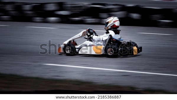Go kart racing field, racer wearing safety\
uniform on competition tournament.\

