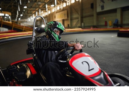 go kart speed drive, focused african american driver in helmet  on circuit, karting motorsport