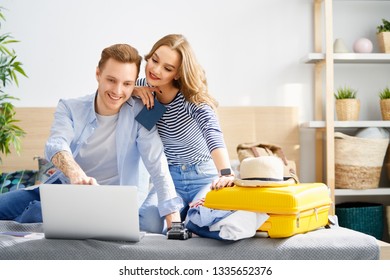 Go On An Adventure! Happy Couple Preparing For The Journey. Young People Are Packing Suitcases For The Trip.