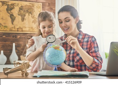 Go on an adventure! Happy family preparing for the journey. Mom and daughter study the map and choose a route of travel. - Powered by Shutterstock