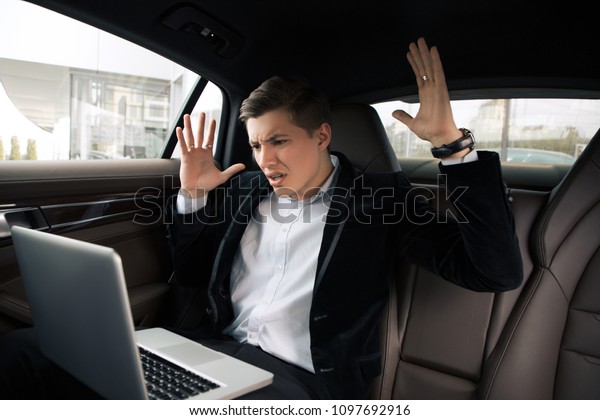 Go on and do not give up! Attractive young\
intelligent man going to the work in the office by car and having\
troubles, while using his\
computer.