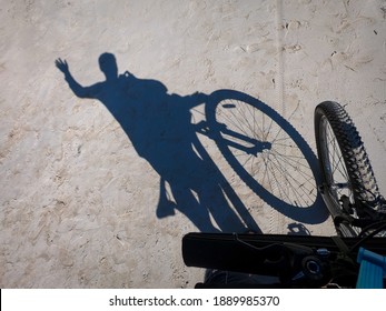 Go Pro Image Of Shadow Of Waving Person With Bicycle On Abandoned Empty Beach. 