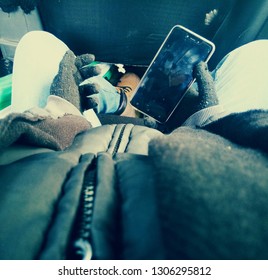 Go Pro View Of Boy Holding Here Phone With Gloves And Wearing Winter Clothes Sitting Inside The Car