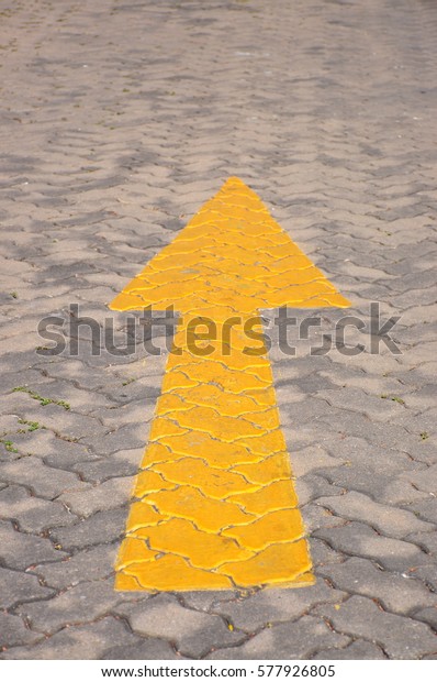 go straight yellow\
arrow sign on road