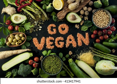 Go Vegan Concept With Lettering. Variety Of Fresh Green Organic Vegetables & Lentils On Dark Background. Vegan Food Concept.