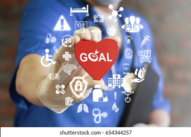 GOAL Health Care. Target In Medicine Treatment. Medical Success Strategy Plan Concept. Purpose Achievement In Hospital Work. Doctor Offers Heart With Goals Icon On Virtual Screen. Healthy Life Style.