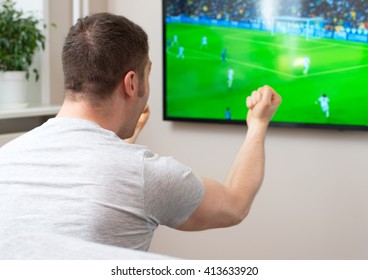 Goal! Man Watching Football Match On Television At Home.