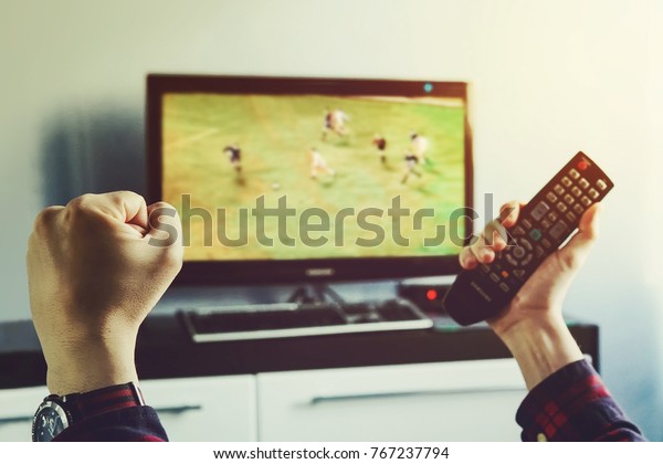 Goal. Man watching football match\
on television at home. remote control in hand. football fan watches\
world Cup soccer and more for your favorite football\
team