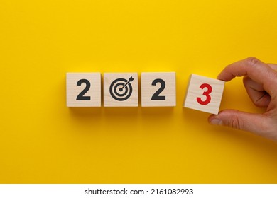 Goal in the new year 2023. Wooden cubes with numbers 2023 and target icon on yellow background. Business development strategy, advancement and goal concept. - Shutterstock ID 2161082993