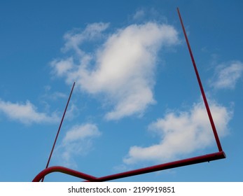 Goal Post On A Football Field. Blue Sky Background With Clouds