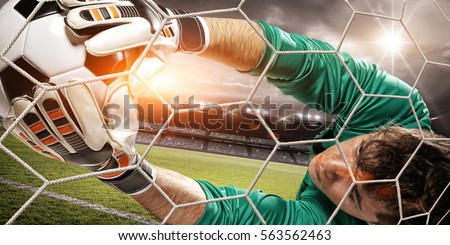 Goalkeeper catches the ball, at the stadium
