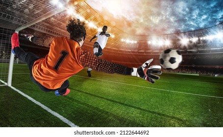 Goalkeeper in orange uniform catches the ball in the stadium during a football game