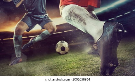 Goalmouth scramble. Two male soccer, football players playing attacking during sport match on sky background at stadium with flashlights. Sport competition. Action, motion, energy and dynamic concept.