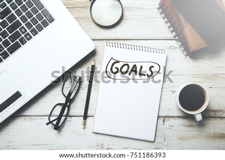 goals text on notepad with computer on table