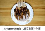 The goat meat satay dish originates from Indonesia. Madurese satay. grilled meat. meat skewered by bamboo sticks. Former President Obama